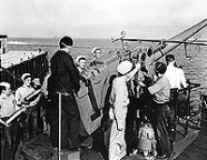 Crewmen exercising with the ship's # three 5/38 gun mount