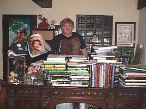 Bill at Ed's carved desk holding JCB's painting of son Johnny