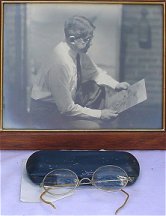 Framed 8 x 10 studio photograph ~ His trademark wire rim glasses and case