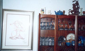 A print of the Disney Tarzan, Hogarth Tarzan statue on top of cabinet